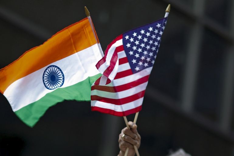 A man holds the flags of India and the US