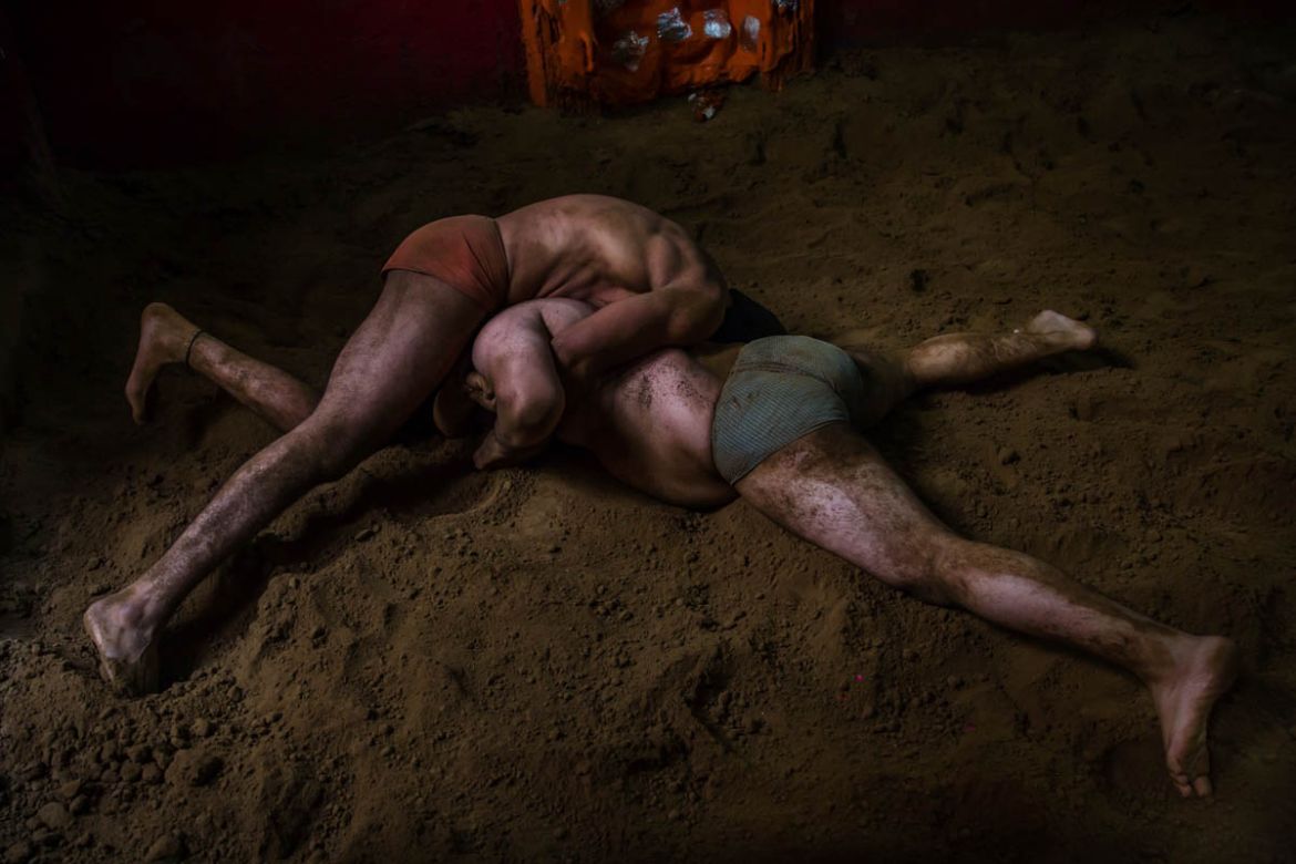 In this Nov. 20, 2017 photo, Indian kushti wrestlers fight in the ring, during their daily training at an akhada, a kind of wrestling hostel at Sabzi Mandi, in New Delhi, India. Like many traditions i