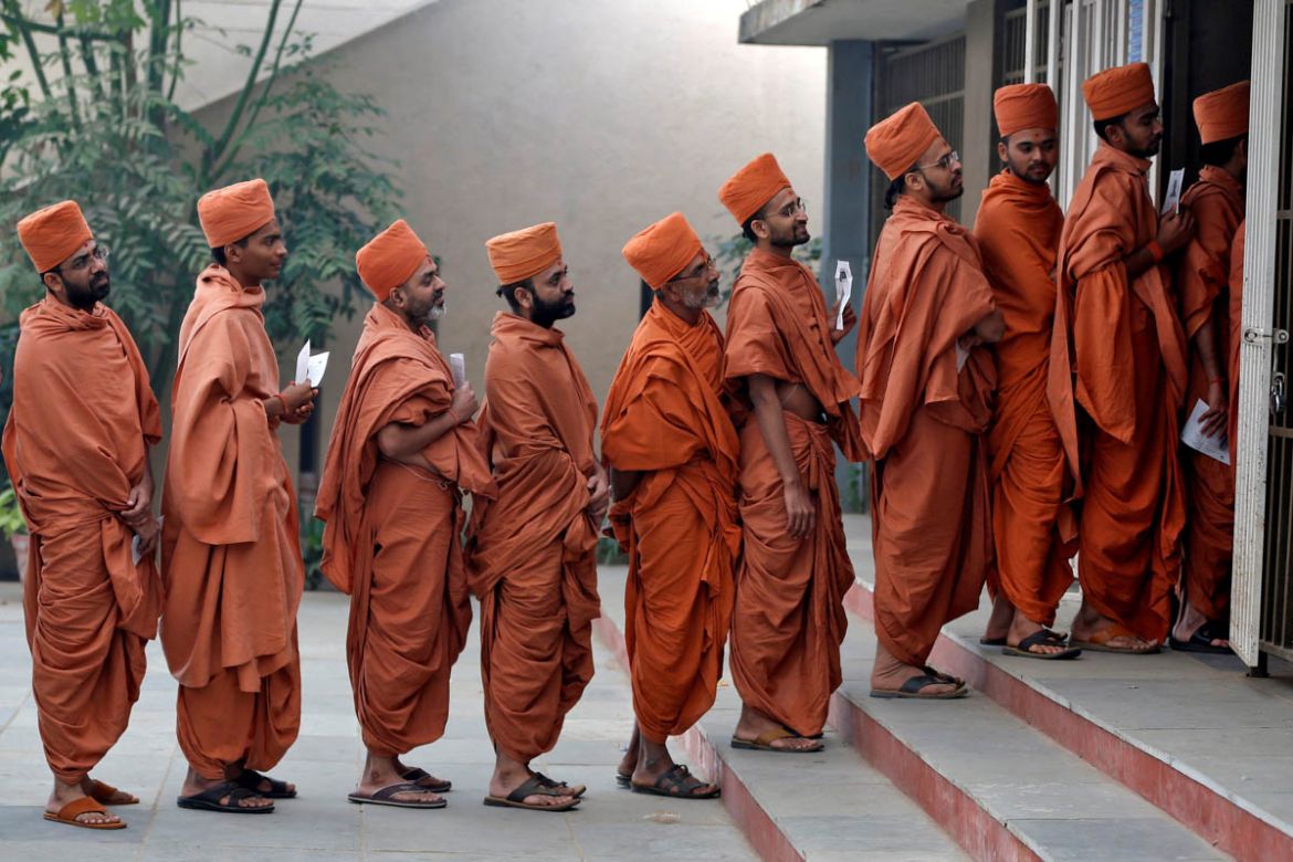 Hindu saints stand in a queue to casts their votes at a polling station during the last phase of Gujarat state assembly election on the outskirts of Ahmedabad, India, December 14, 2017. REUTERS/Amit D