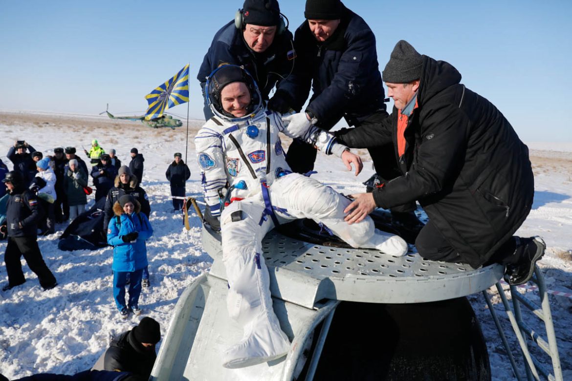 Russian space agency specialists help Russian cosmonaut Sergey Ryazanskiy shortly after the landing of the Russian Soyuz MS-05 space capsule about 150 km ( 80 miles) south-east of the Kazakh town of Z