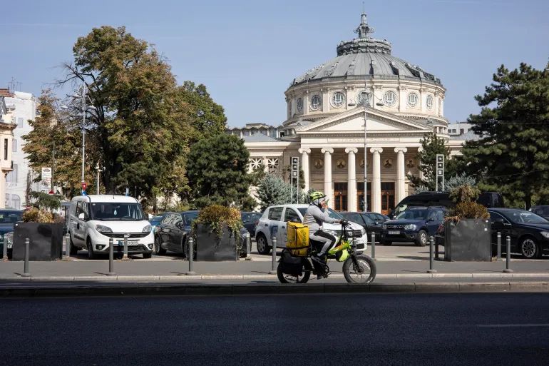 Delivery riders, who often hail from Asia, work relentlessly across Romanian cities.