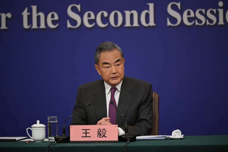 Wang Yi at a press conference in Beijing. He is sitting at a desk.