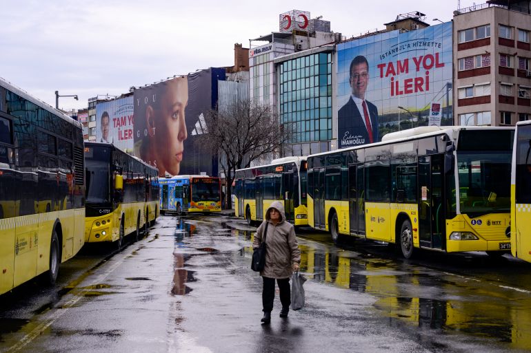 A pedestrian walks past an electoral poster displaying Republican People's Party (CHP) candidate Ekrem Imamoglu in Istanbul on March 25, 2024, ahead of the March 31 municipal elections.