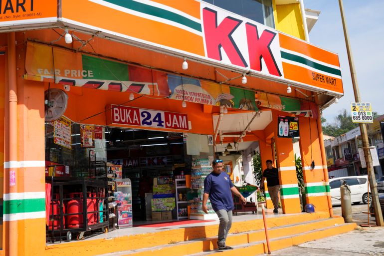 A customer walks out from KK Mart convenience store in the Puchong area on the outskirts of of Kuala Lumpur, Malaysia