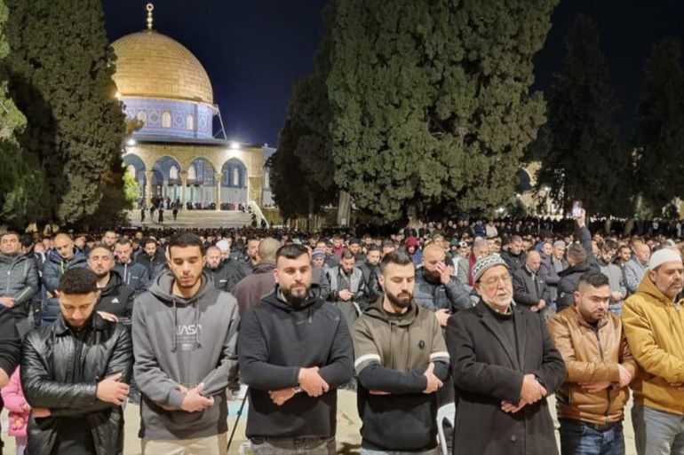 Muslim worshippers in rows in front of Al-Aqsa mosque, performing evening prayers on the first day of fasting in Ramadan.