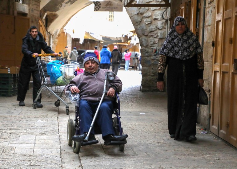 Qafisheh on his wheelchair going through the old alleys