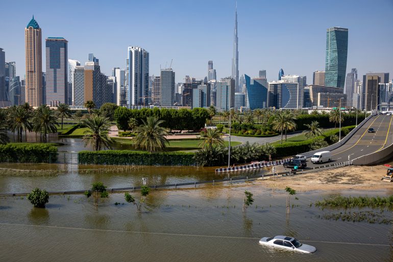 An abandoned vehicle stands in floodwater caused by heavy rain with the Burj Khalifa, the world's tallest building, seen on the background, in Dubai, United Arab Emirates, Thursday, April 18