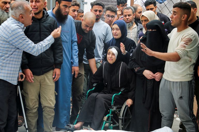 Mourners react during the funeral of Palestinians killed in Israeli strikes