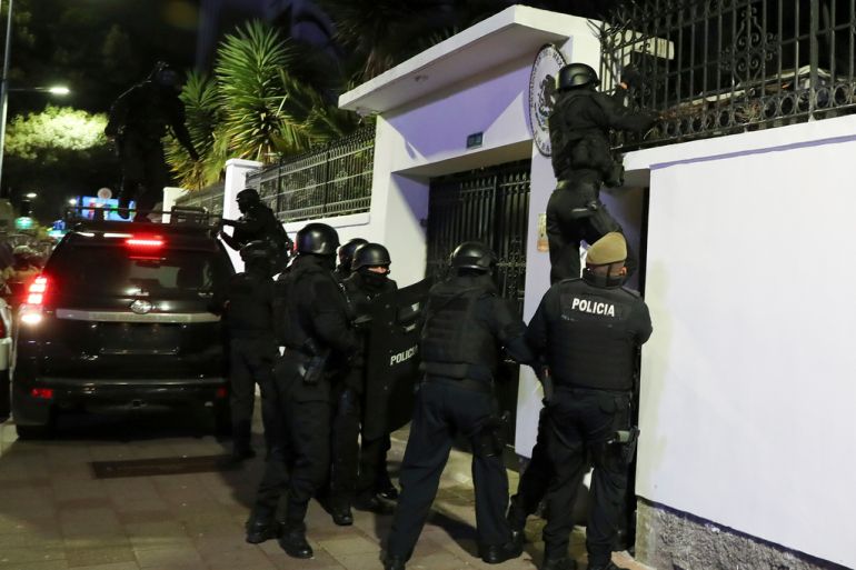 Police scale the fence of the Mexican embassy in the Ecuadorian capital of Quito