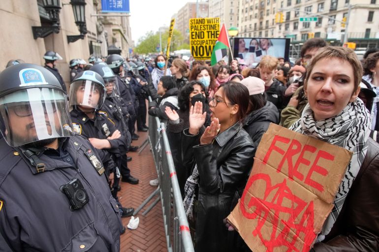 Police in Riot gear stand guard as demonstrators chant slogans outside the Columbia University campus,